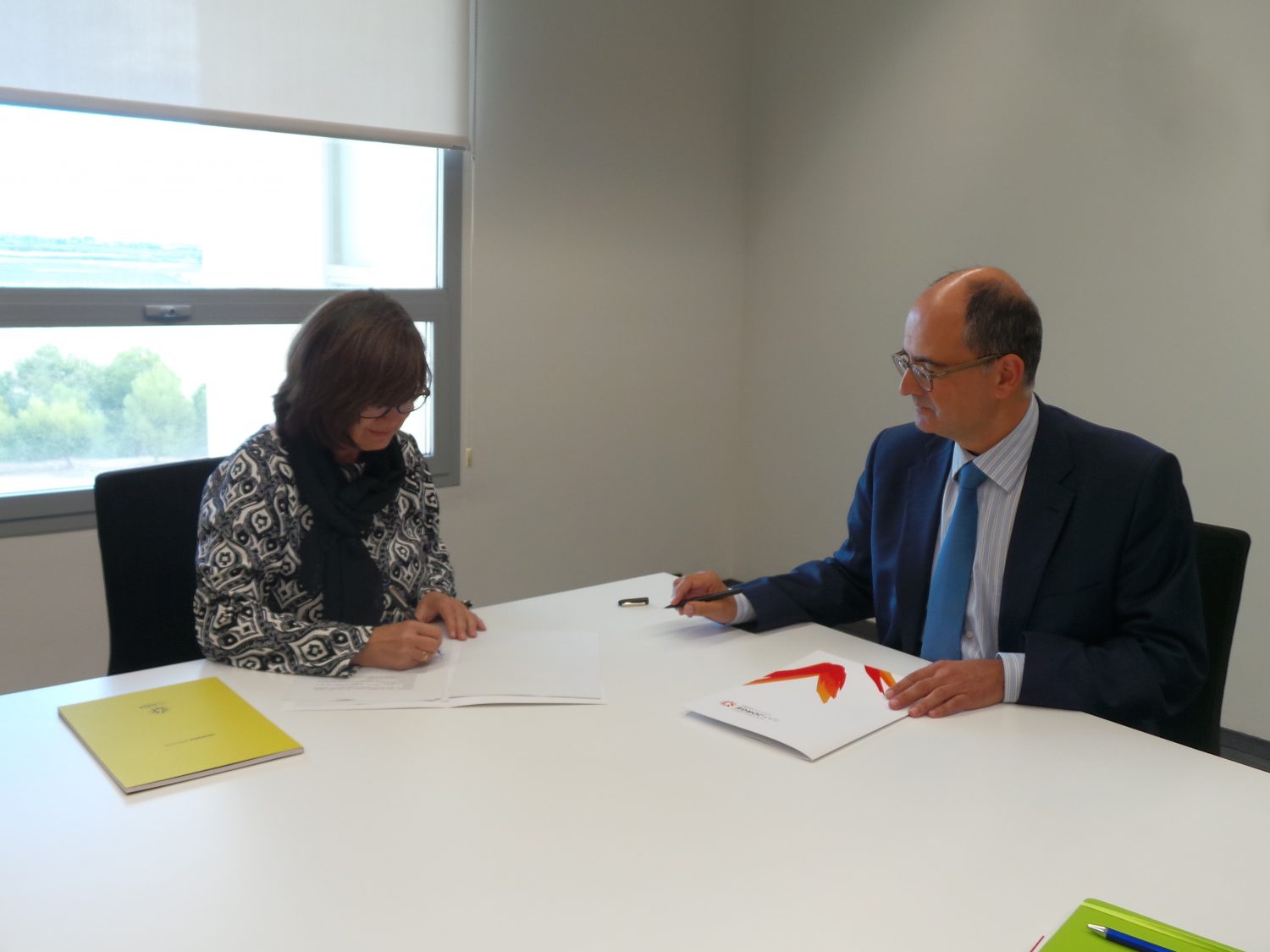 La presidenta de APAE, Lourdes Zuriaga, y el rector de la Universidad San Jorge, Carlos Pérez Caseiras, durante la firma del convenio entre ambas entidades. 