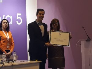 El periodista David Centellas recoge el diploma de manos de la presidenta de APAE, Lourdes Zuriaga